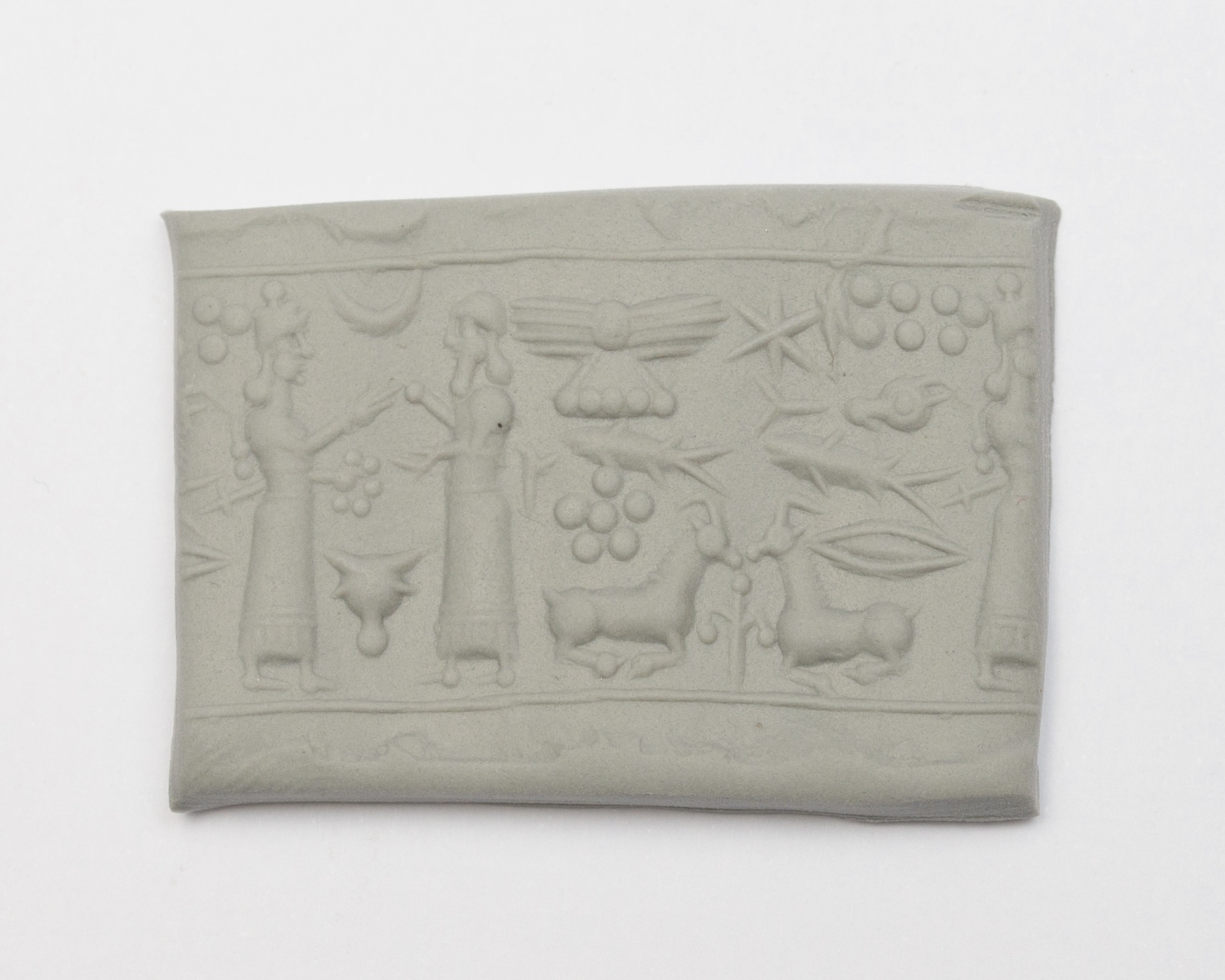 a seal impression set in a piece of clay, featuring three figures and an assortment of animals