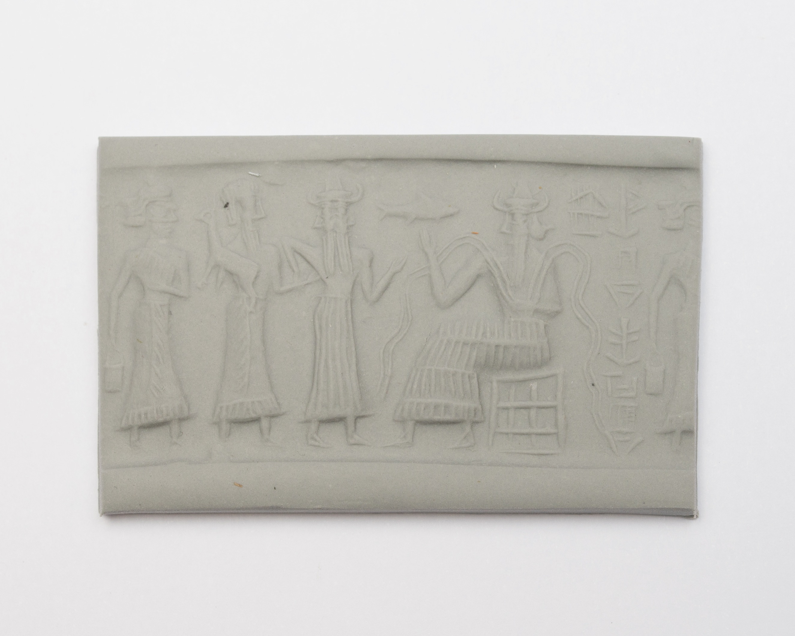 a seal impression set in a piece of clay, featuring four figures and cuneiform writing