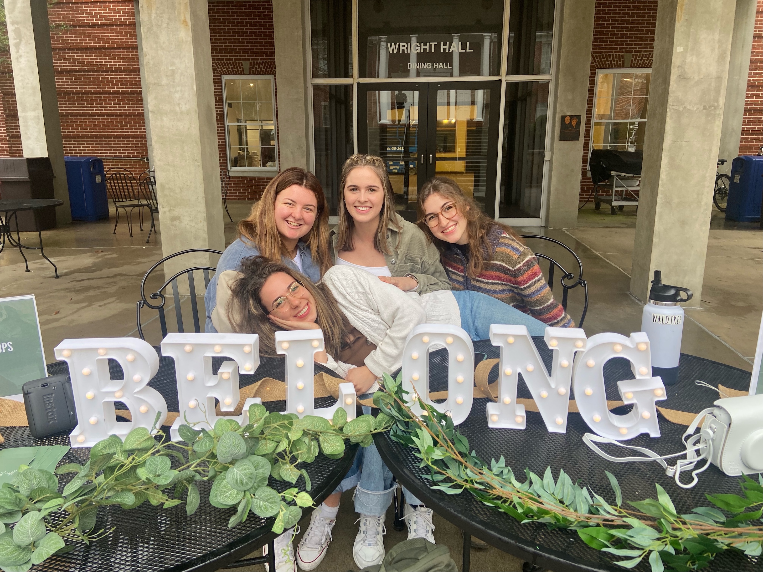 people sitting in front of a velong sign