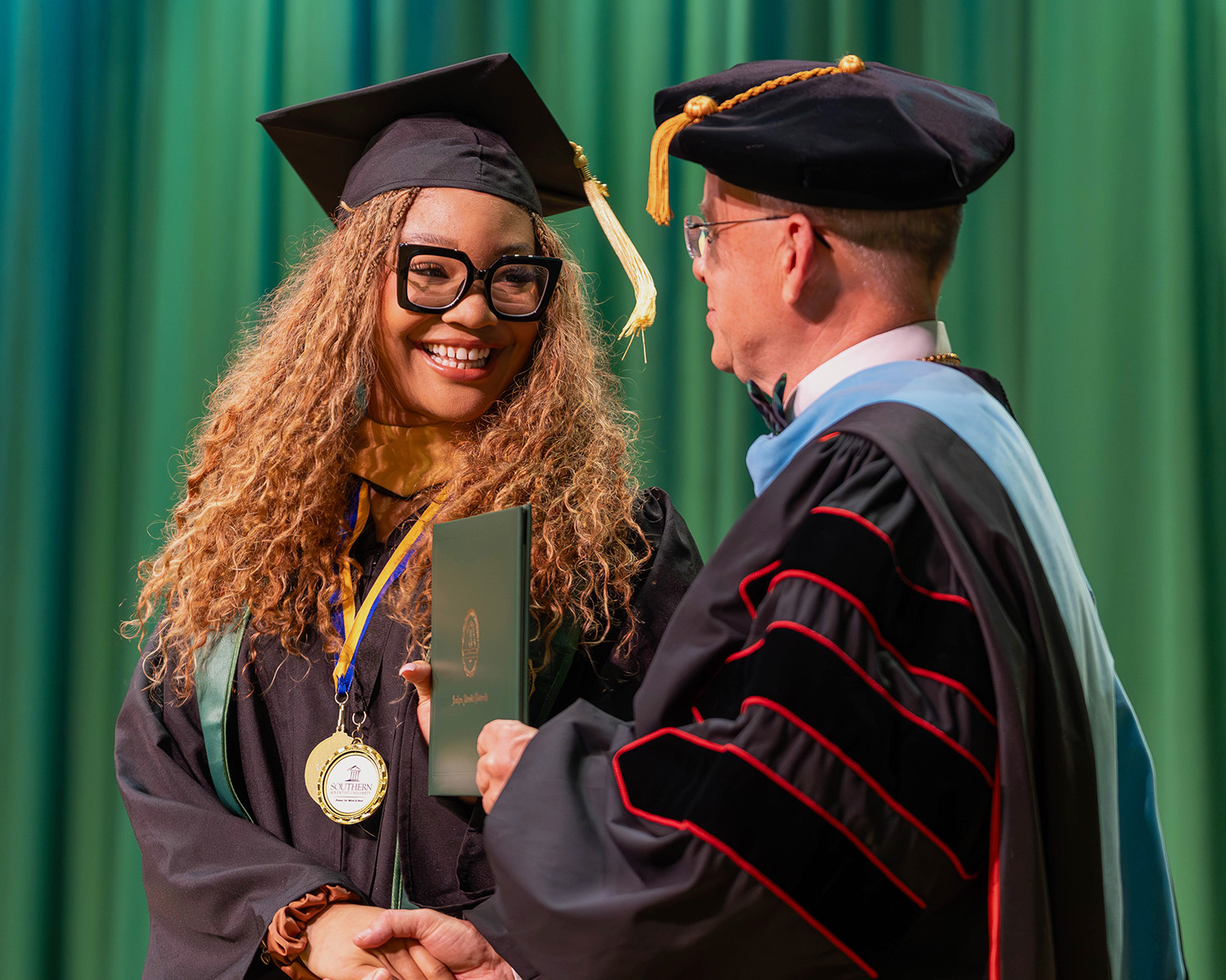 a Southern Adventist University graduate accepts her diploma from University President Ken Shaw.