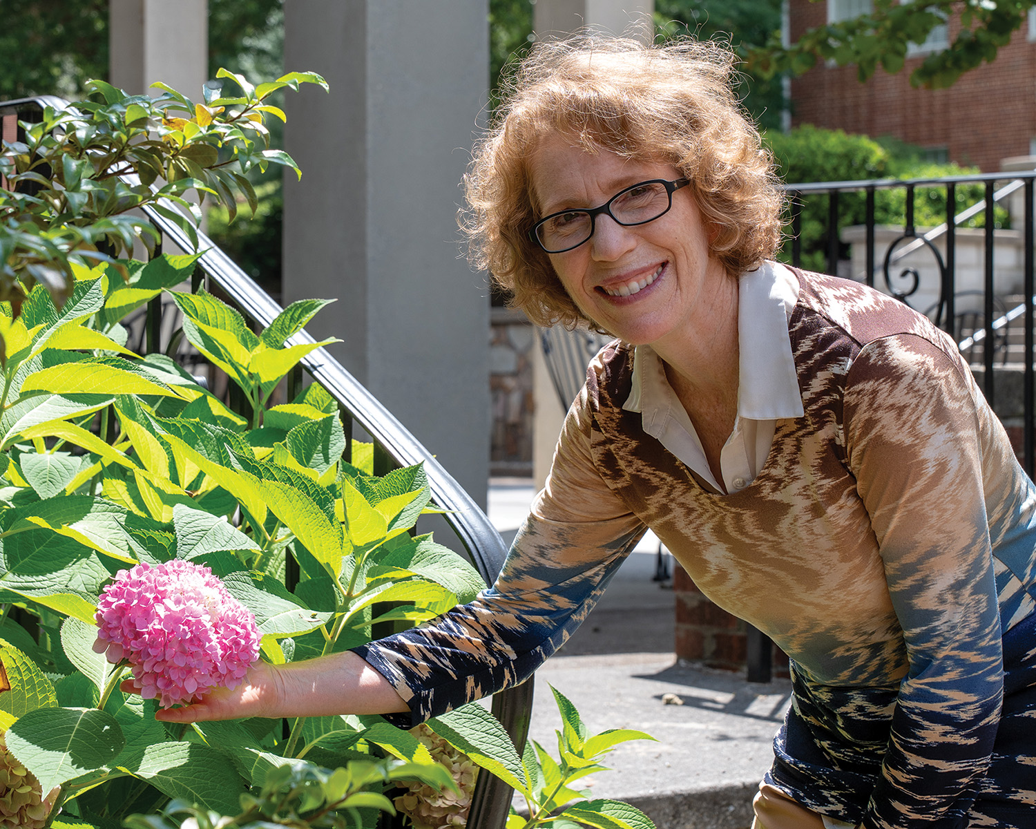 Cheryl Craven admires a hydrangea along the promenade at Southern Adventist University