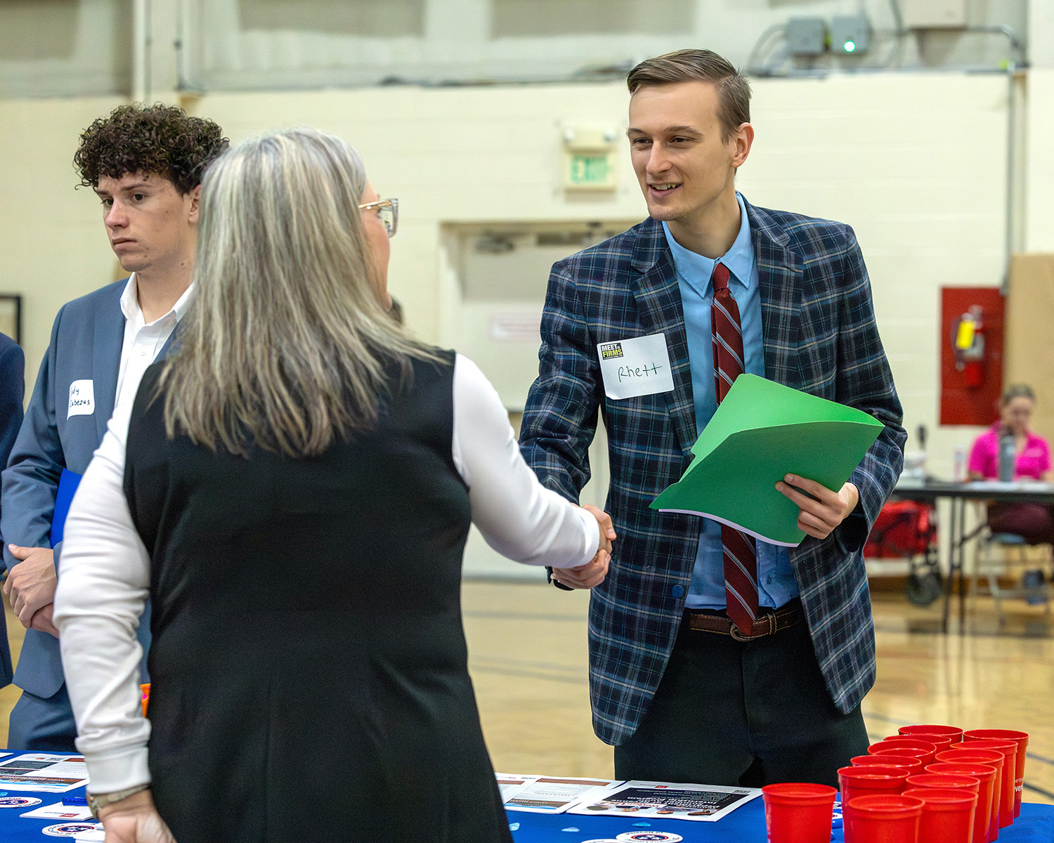 A student shaking hands with a professional