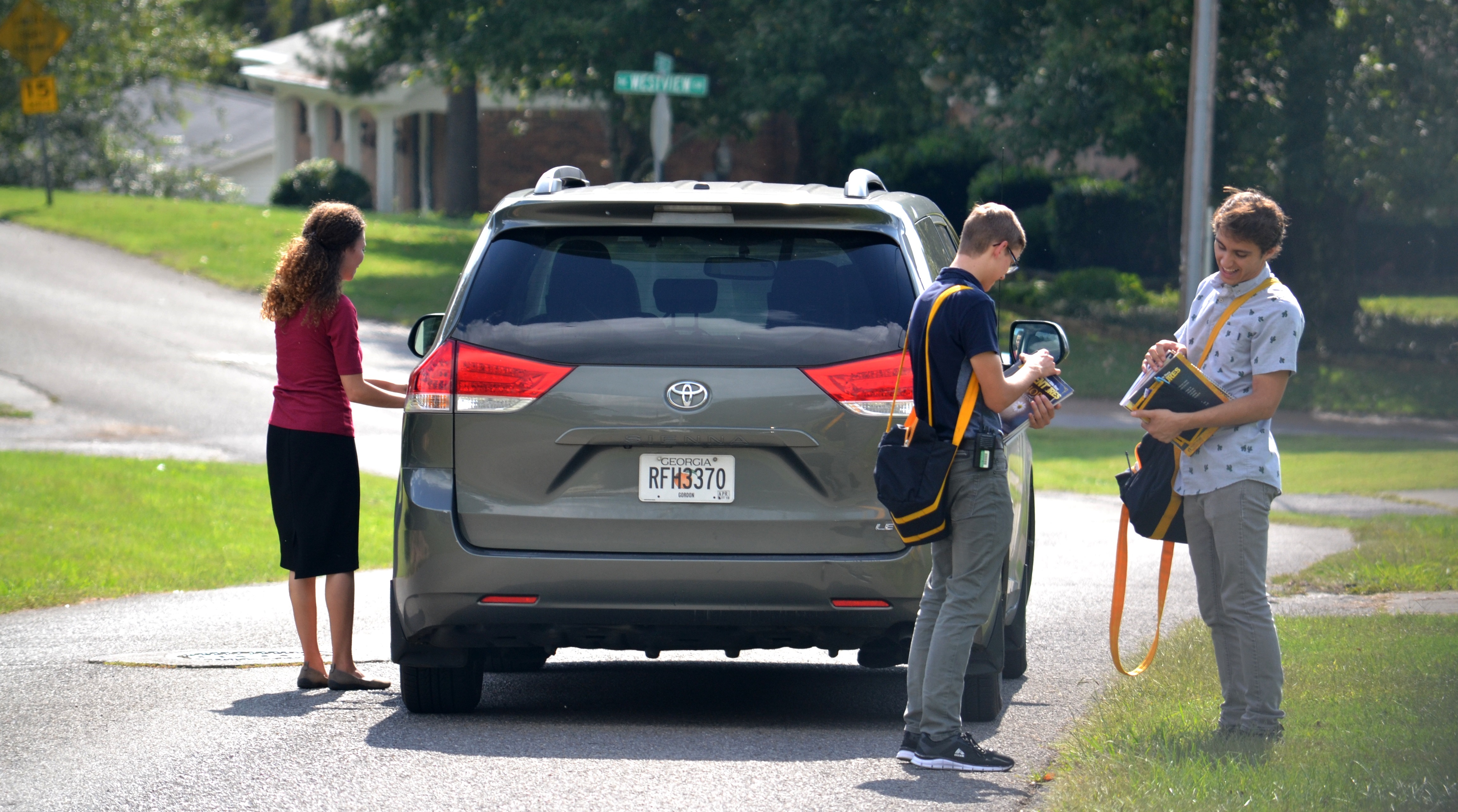 Workers standing outside a car