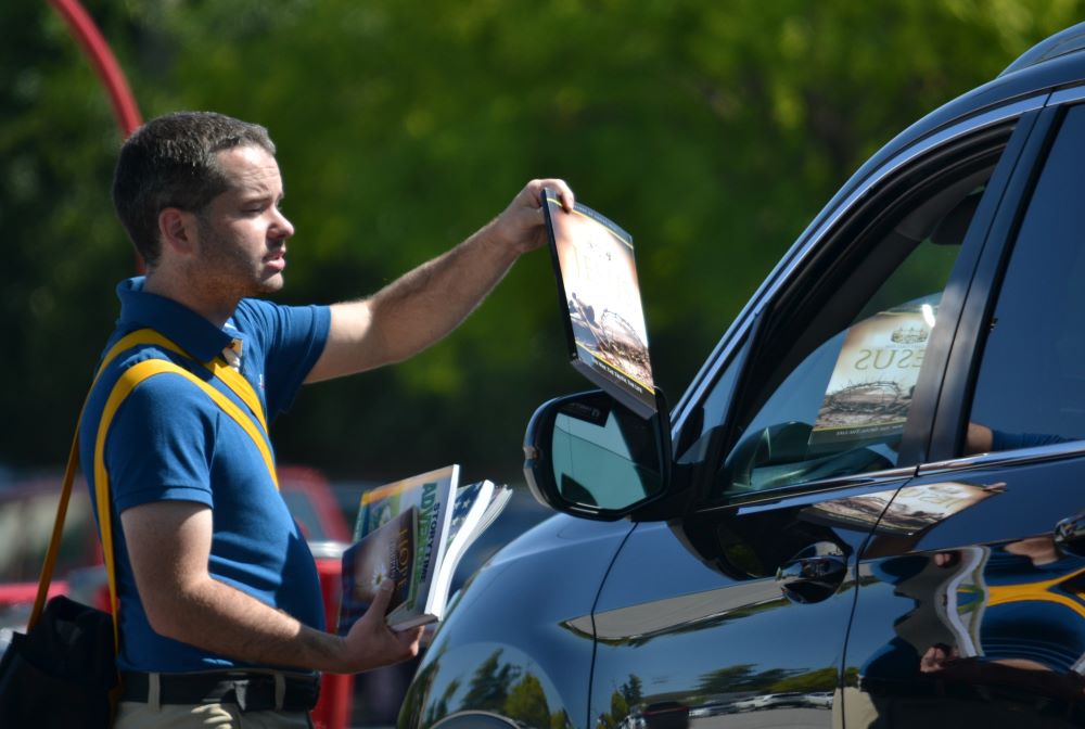 A person handing someone a book