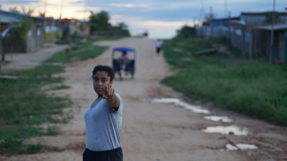 a girl standing om a dirt road