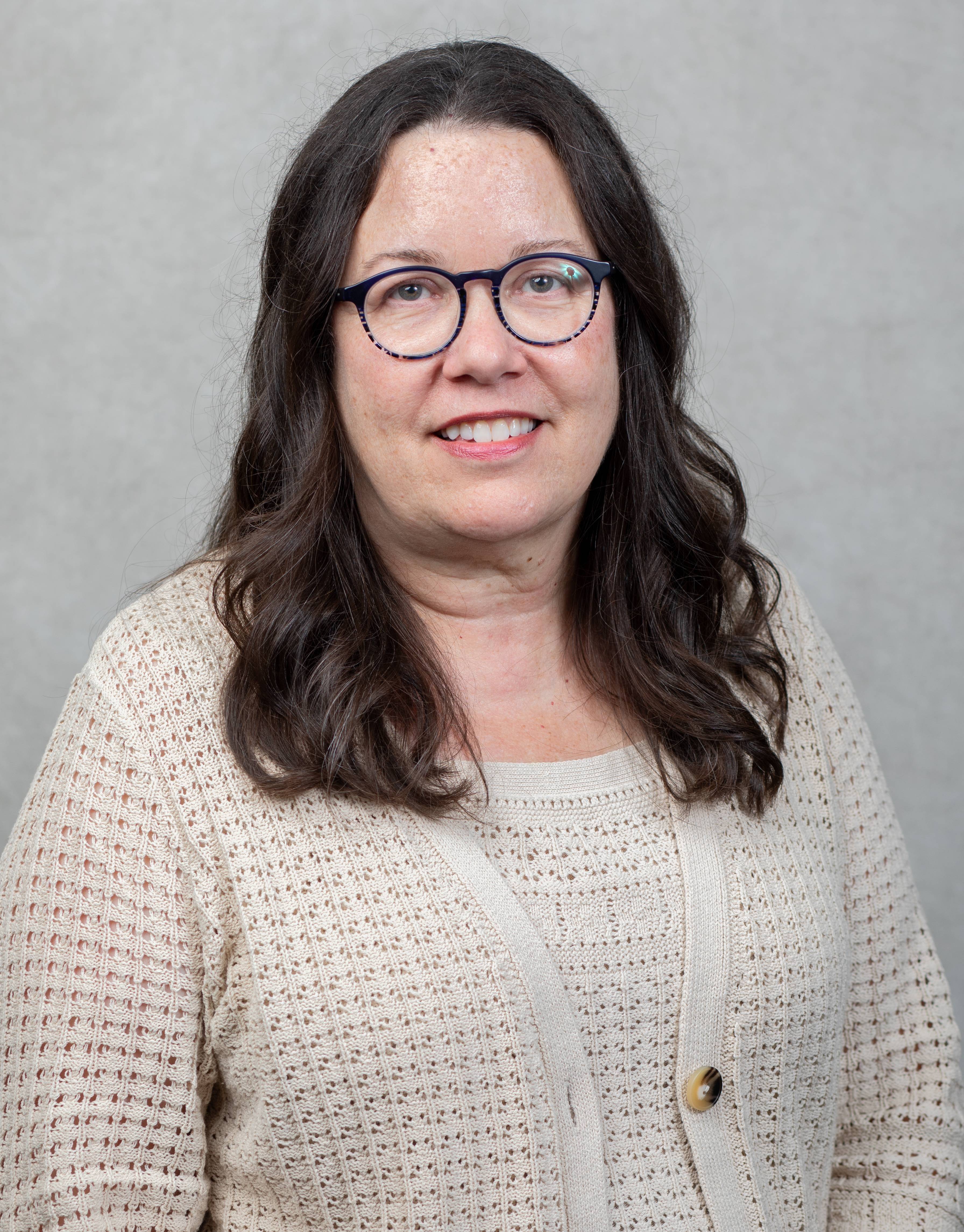 An image of Lisa wearing glasses and a professional white shirt. 