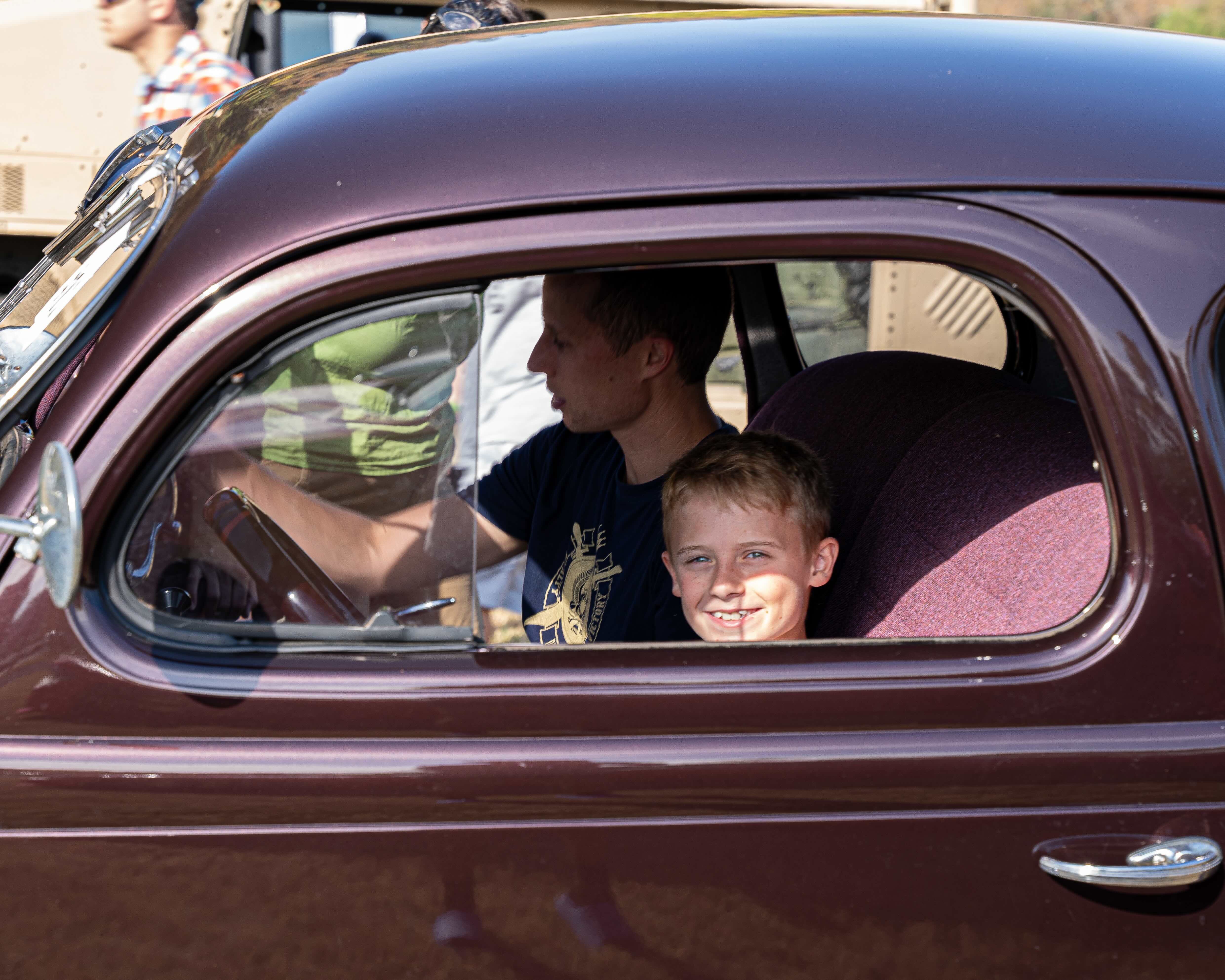 Kid sitting in an antique car
