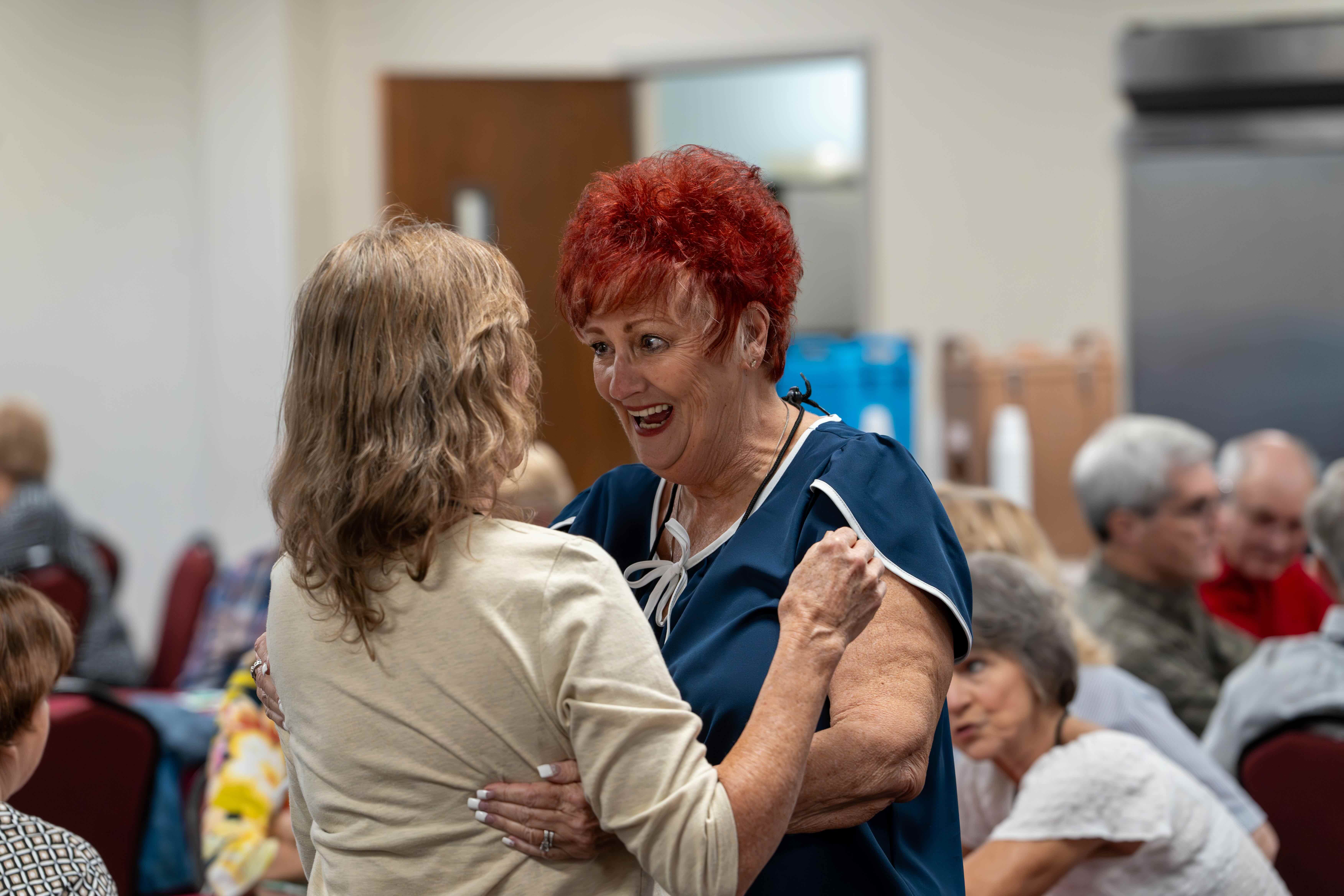 Homecoming Weekend Photo of 2 alumni enthusiastically greeting each other