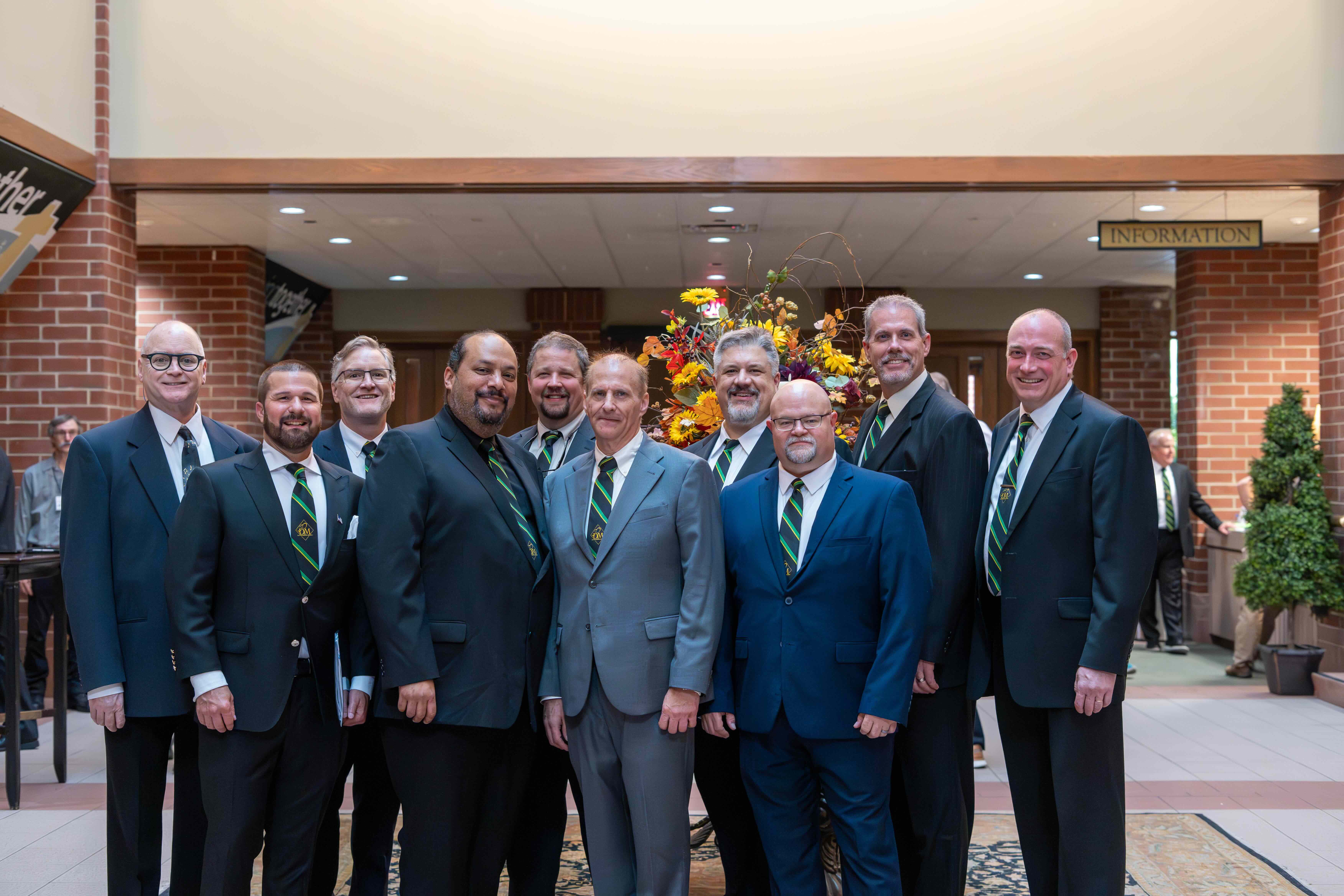 Homecoming Weekend Photo of 10 Die Meistersingers in their performance attire standing in the atrium of the church