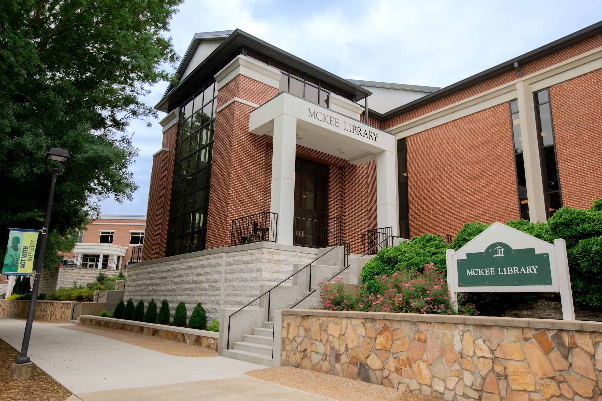 The front of the red-brick McKee Library entrance, taken from the promenade in front of it