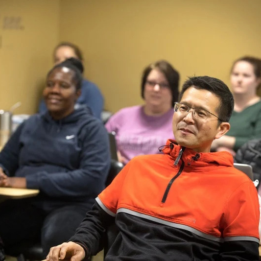 Five adult students sitting in a Southern classroom listening to a lecture.