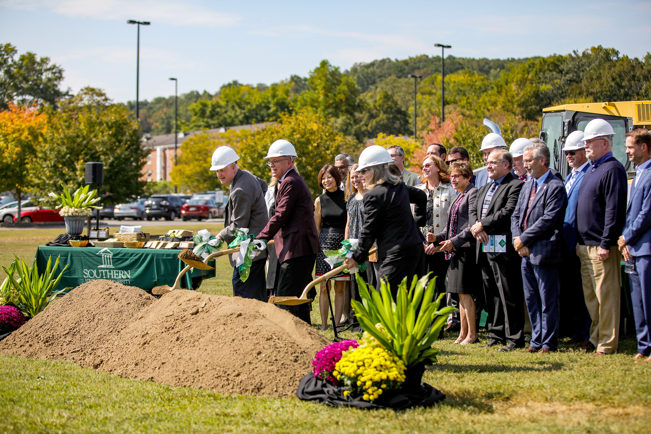 administrators shoveling dirt at the building site.