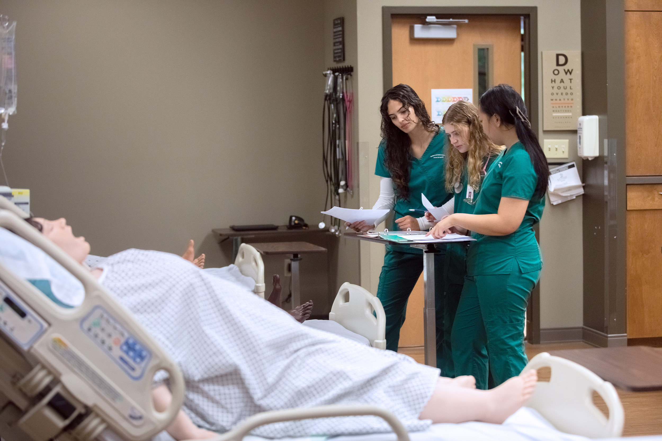 A group of students prepares to practice their skills on the new R42 Bariatric Manikin at Southern Adventist University.