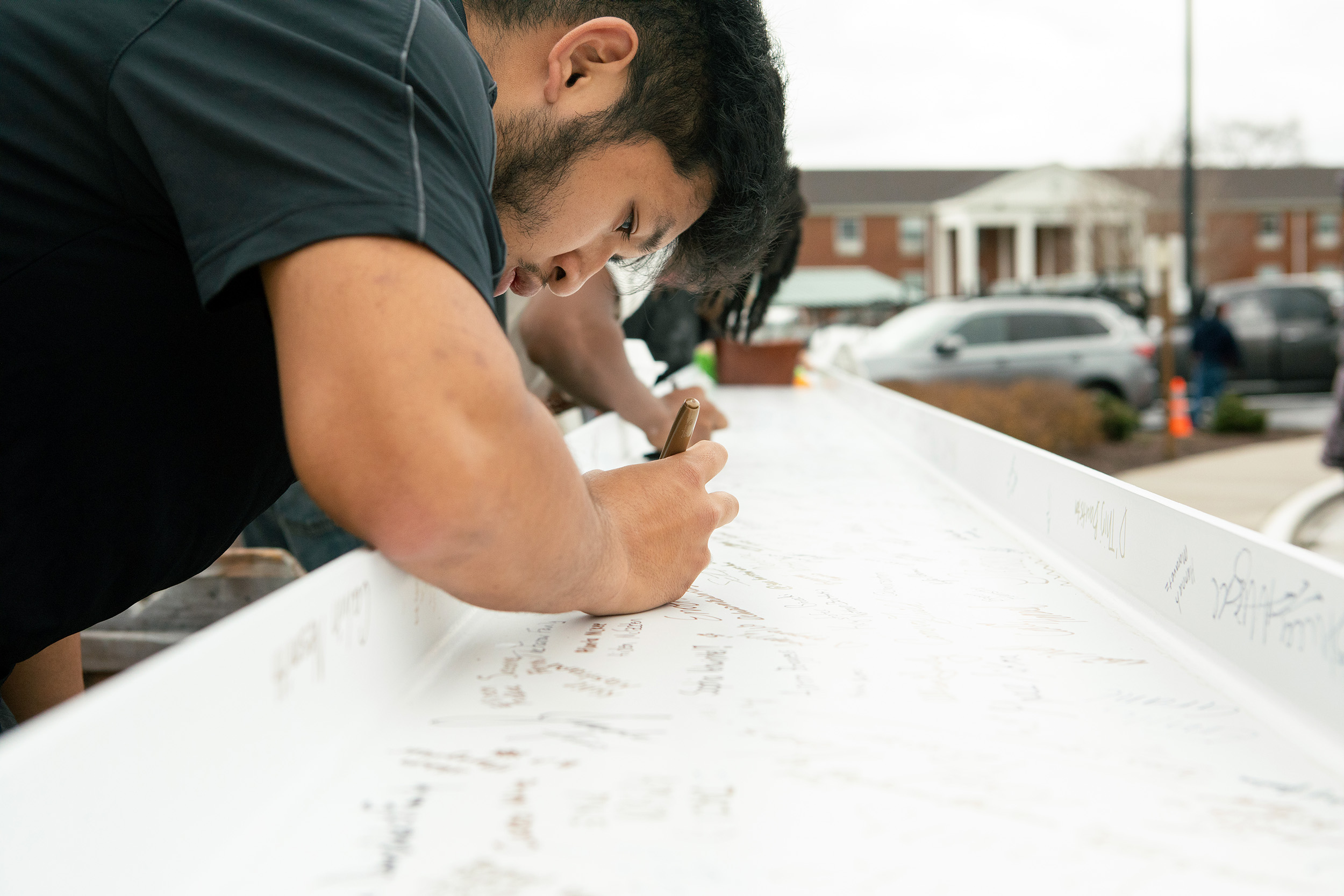 A student signs the beam.