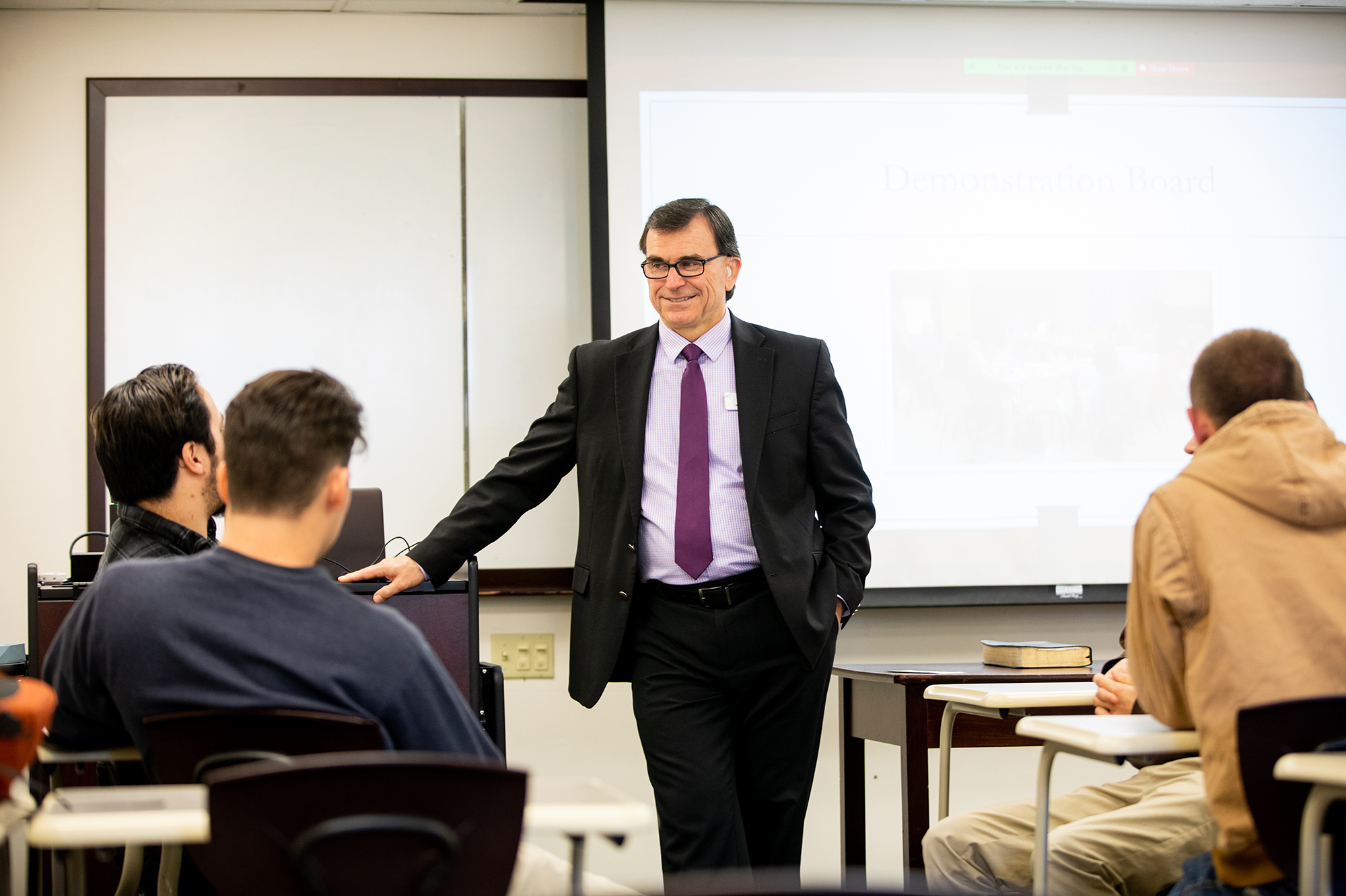 Students and instructor are gathered in a classroom.